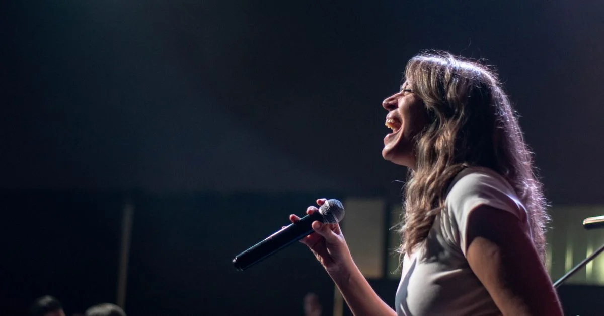 Chanteuse charismatique se produisant avec passion sur scène lors d'un concert en direct.