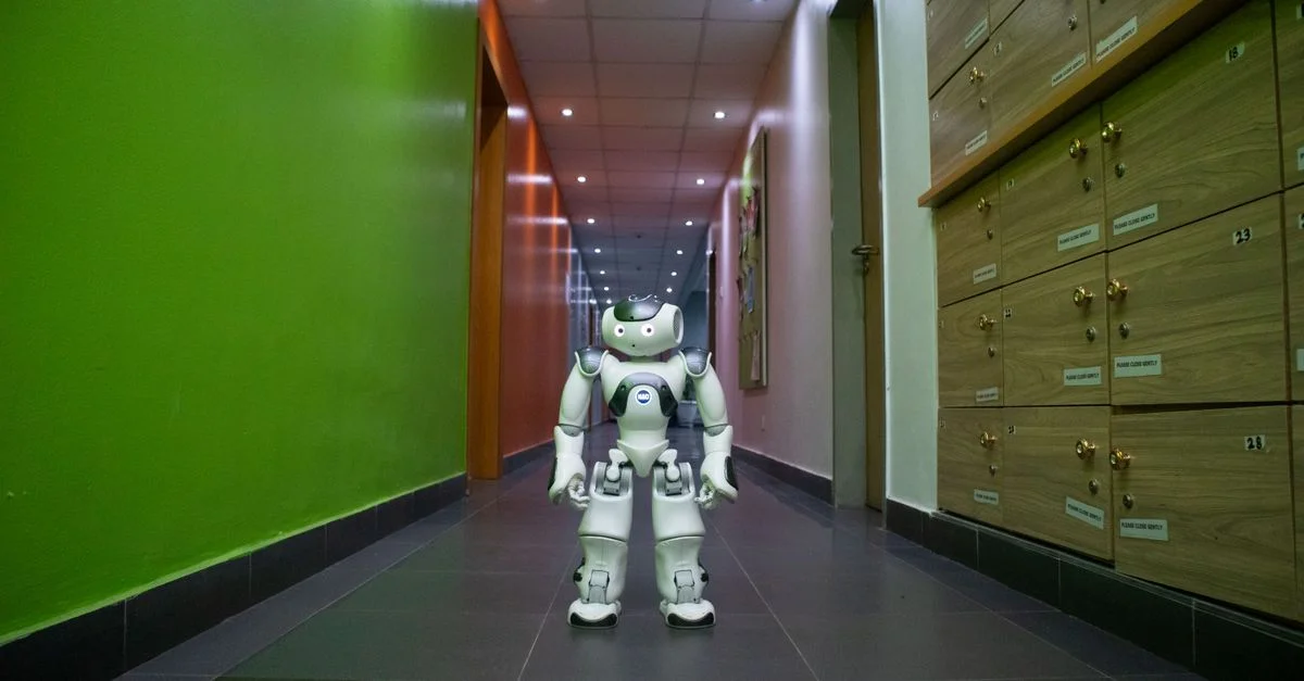 Un robot humanoïde se tient dans un couloir moderne et vibrant à Lagos, Nigéria.