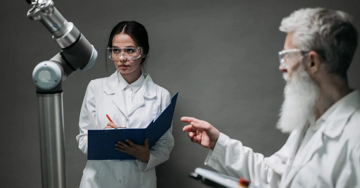 Des scientifiques en blouses de laboratoire analysent une technologie de robotique avancée, mettant en avant l'innovation et le travail d'équipe.
